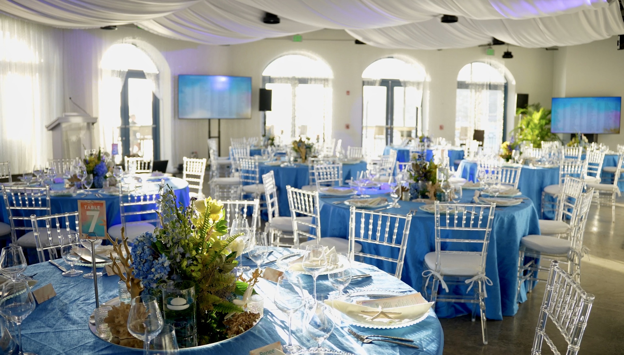 Elegant ballroom dining setup with ocean-themed decor